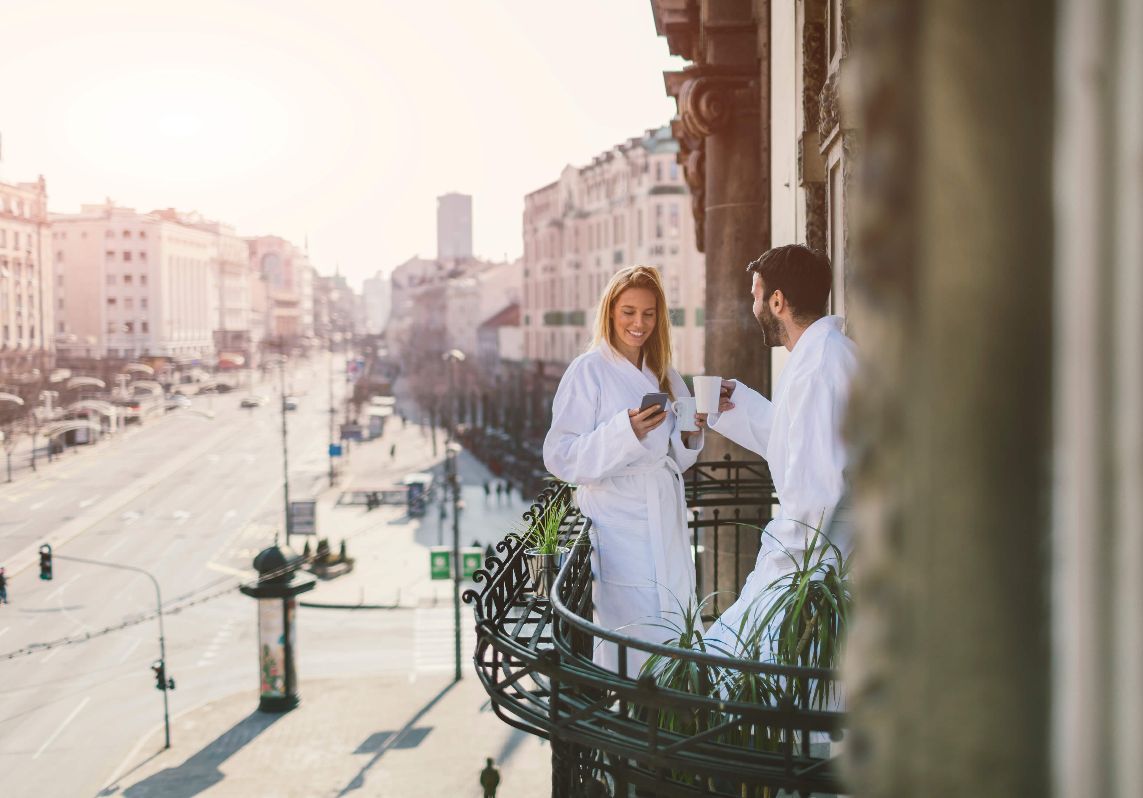 Stel geniet samen van een romantische hotelovernachting op een balkon in de stad
