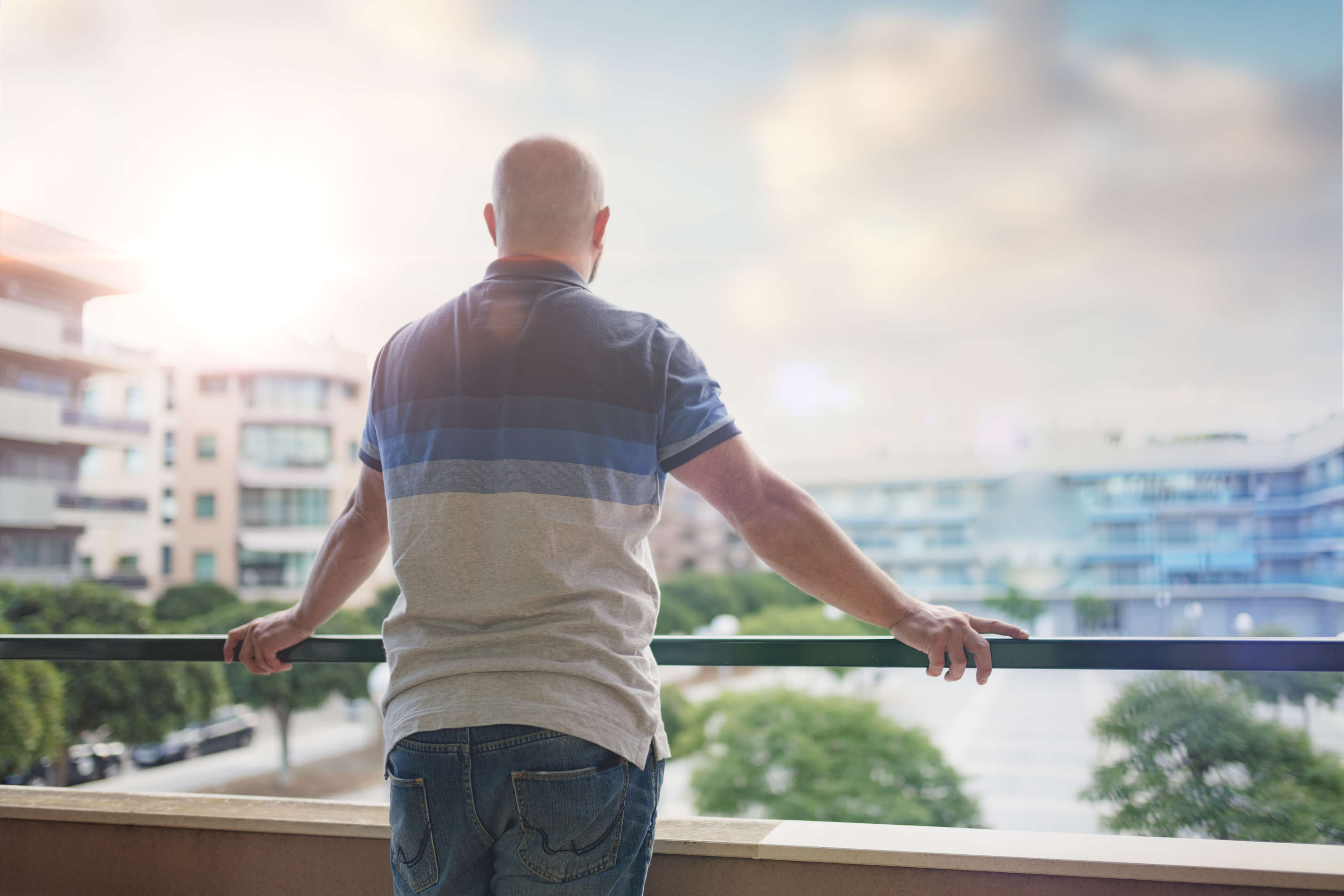 Man geniet van een rustig moment op een hotelbalkon met uitzicht op de stad